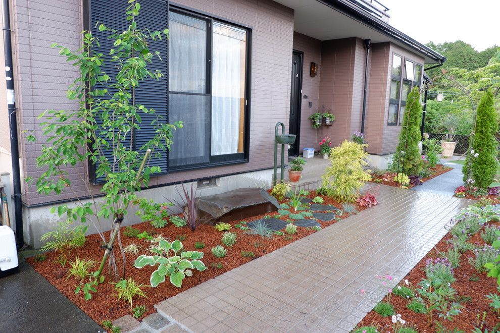 Modelo de jardín de estilo de casa de campo en patio delantero con exposición total al sol y mantillo