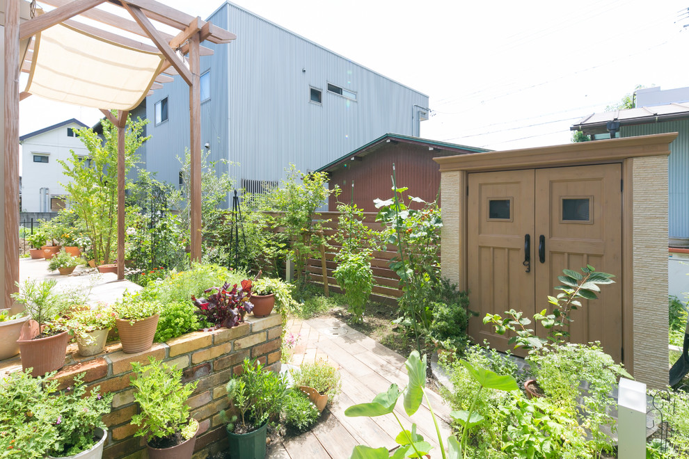 Diseño de jardín de estilo de casa de campo en patio trasero con exposición total al sol y adoquines de ladrillo