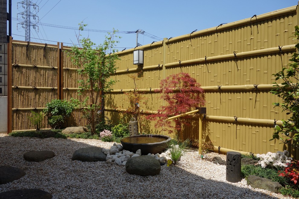 Diseño de jardín de estilo zen de tamaño medio en patio trasero con jardín francés, fuente, gravilla y exposición parcial al sol