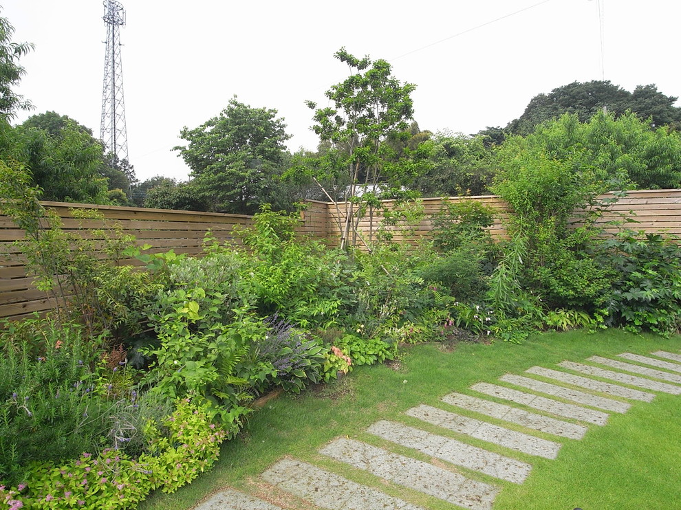 他の地域にあるカントリー風のおしゃれな庭 (庭への小道、日向、天然石敷き) の写真