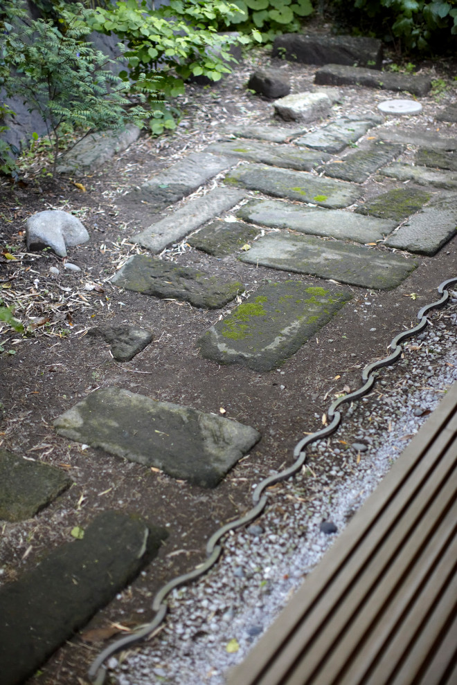 Schattiger Asiatischer Garten im Frühling, hinter dem Haus mit Auffahrt, Steindeko und Natursteinplatten in Sonstige
