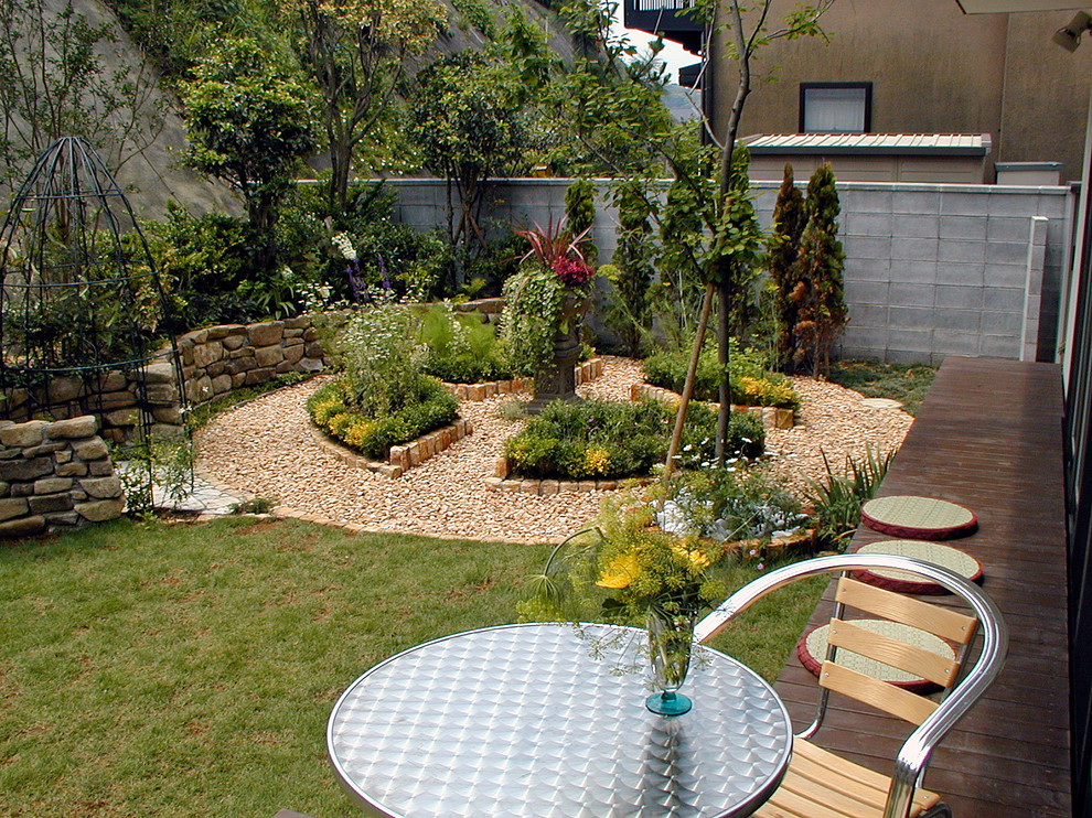 Immagine di un giardino etnico esposto in pieno sole davanti casa in primavera con pedane