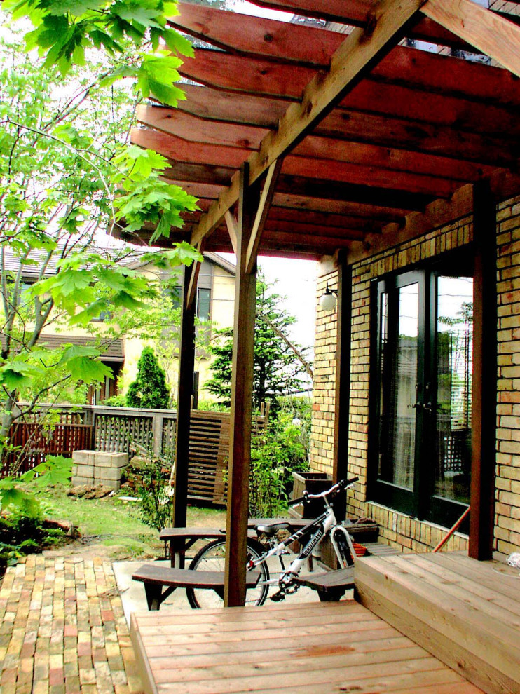 На фото: весенний участок и сад среднего размера на боковом дворе с с деревянным забором и полуденной тенью с
