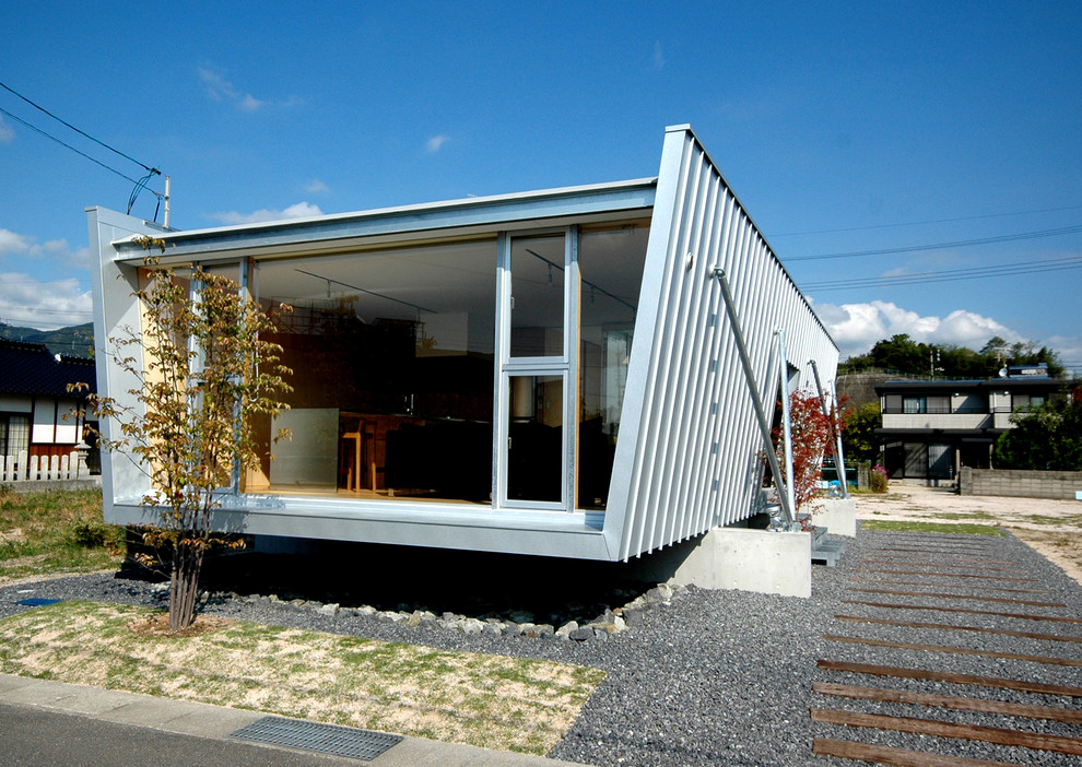 Exemple d'une petite façade de maison grise moderne de plain-pied avec un toit plat.
