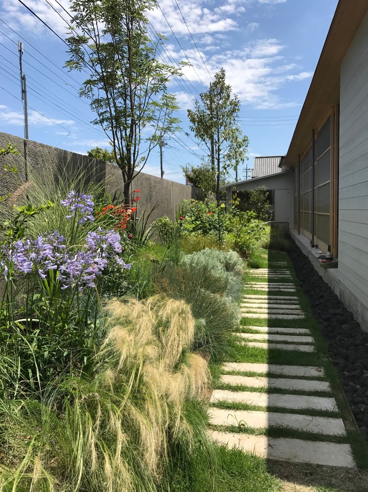 Idées déco pour un jardin latéral moderne l'automne avec une exposition partiellement ombragée et des pavés en pierre naturelle.