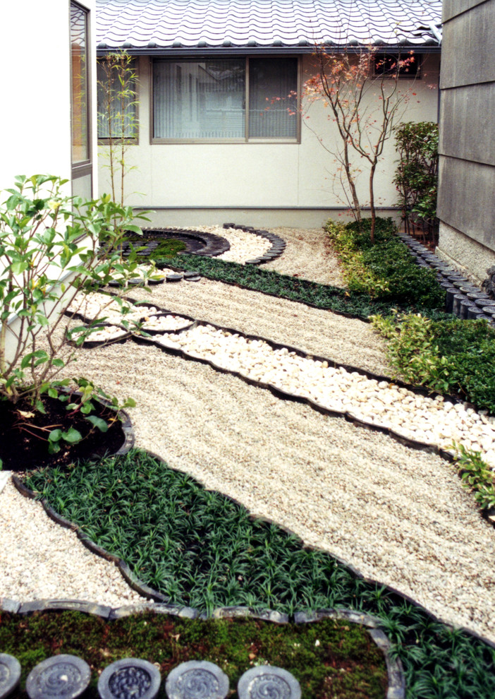 Ejemplo de jardín asiático en patio trasero con jardín francés y adoquines de piedra natural