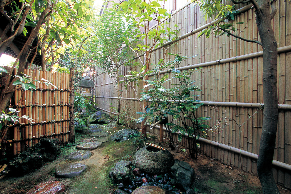 Aménagement d'un jardin asiatique avec des pavés en pierre naturelle et pierres et graviers.