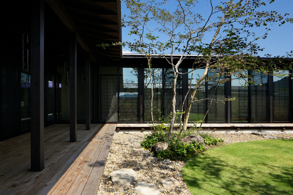 Cette image montre un jardin arrière minimaliste avec une terrasse en bois.