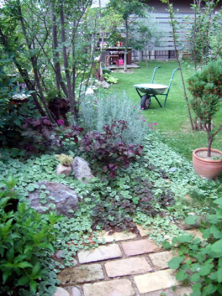Immagine di un giardino country esposto in pieno sole di medie dimensioni e in cortile in primavera con pavimentazioni in mattoni