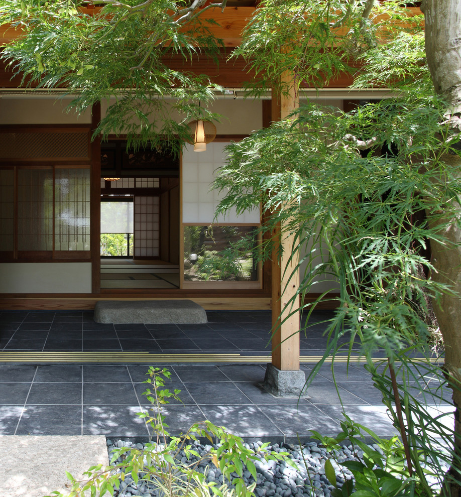 Diseño de jardín asiático de tamaño medio en verano en patio con privacidad, exposición total al sol, adoquines de piedra natural y con madera