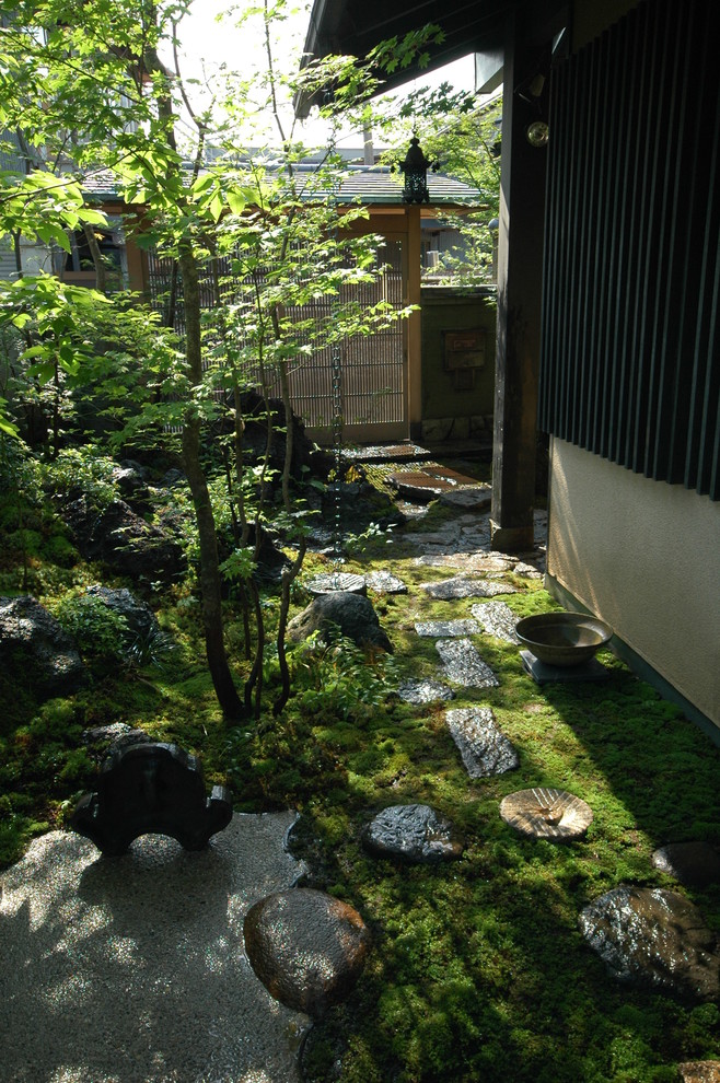 Ejemplo de jardín de estilo zen de tamaño medio en verano en patio delantero con adoquines de piedra natural, jardín francés y exposición parcial al sol