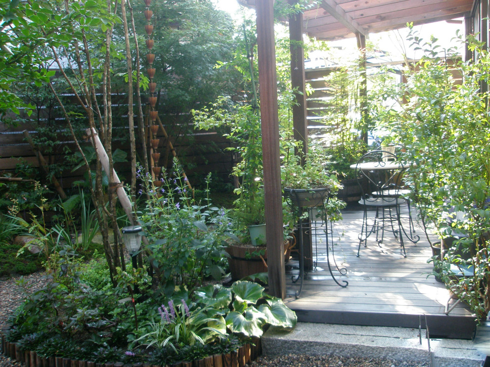 Ispirazione per un giardino in ombra di medie dimensioni e dietro casa in autunno con recinzione in legno