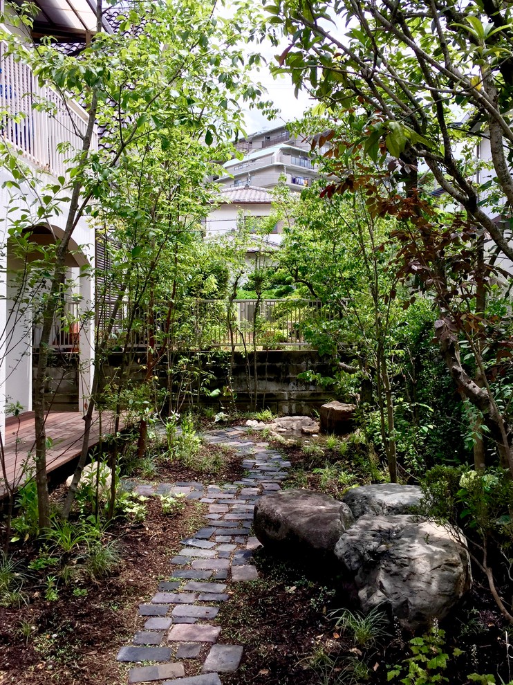 Halbschattiger Asiatischer Vorgarten mit Auffahrt und Natursteinplatten in Osaka