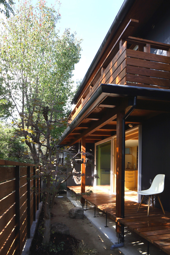 Cette image montre un jardin minimaliste avec une exposition partiellement ombragée et une terrasse en bois.