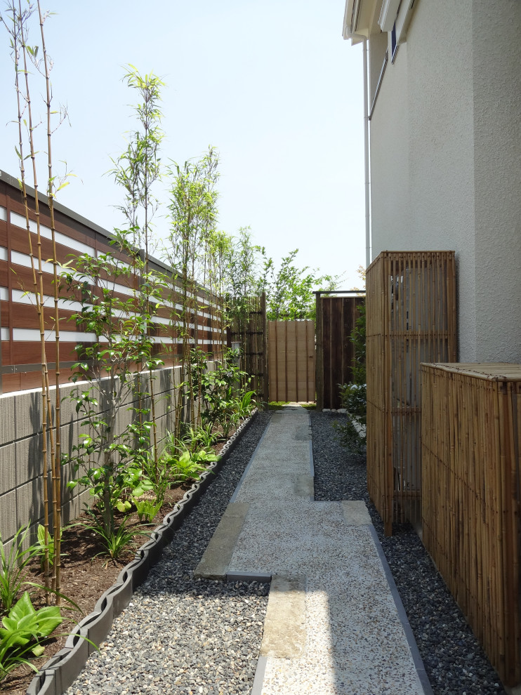 На фото: участок и сад на боковом дворе в восточном стиле с садовой дорожкой или калиткой и полуденной тенью с