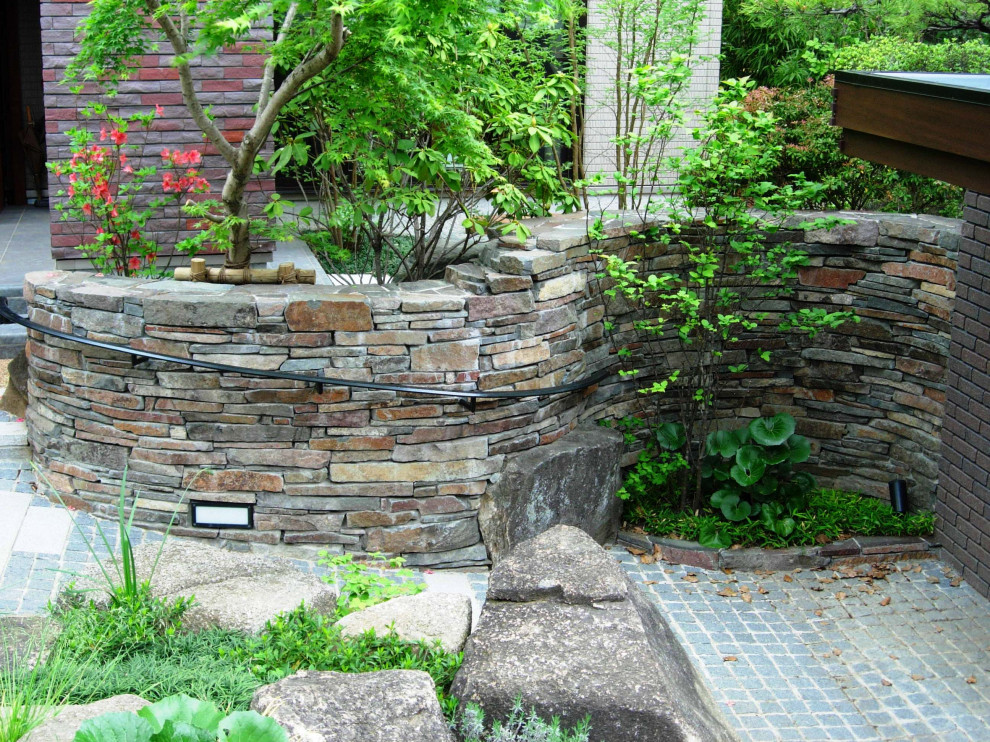 Пример оригинального дизайна: большой весенний участок и сад на склоне в классическом стиле с камнем в ландшафтном дизайне, полуденной тенью и покрытием из каменной брусчатки