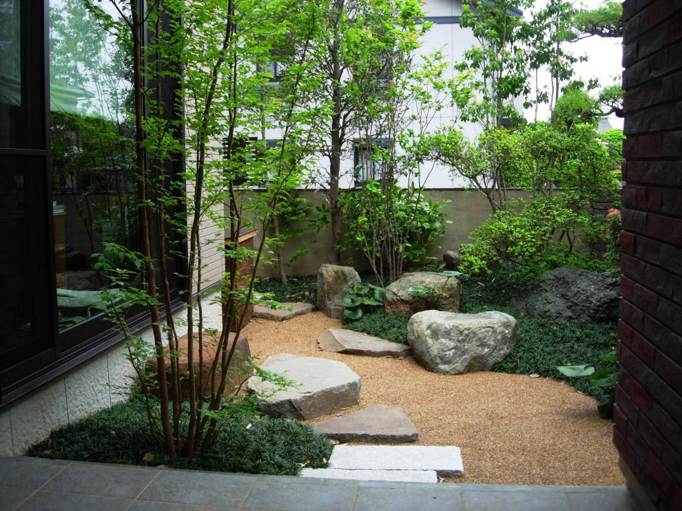 Idee per un grande giardino chic esposto a mezz'ombra in cortile in primavera con sassi e rocce e pavimentazioni in pietra naturale