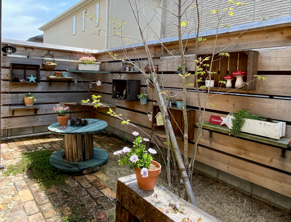 Diseño de jardín urbano pequeño en primavera en patio con exposición parcial al sol y adoquines de ladrillo