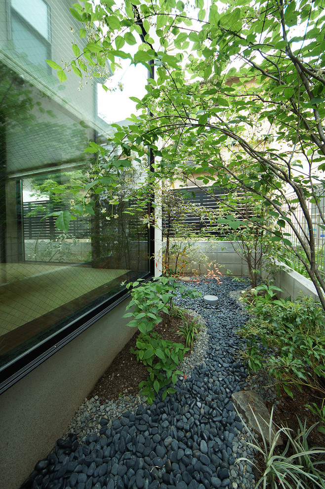 На фото: маленький летний регулярный сад на заднем дворе в стиле модернизм с полуденной тенью и покрытием из каменной брусчатки для на участке и в саду с