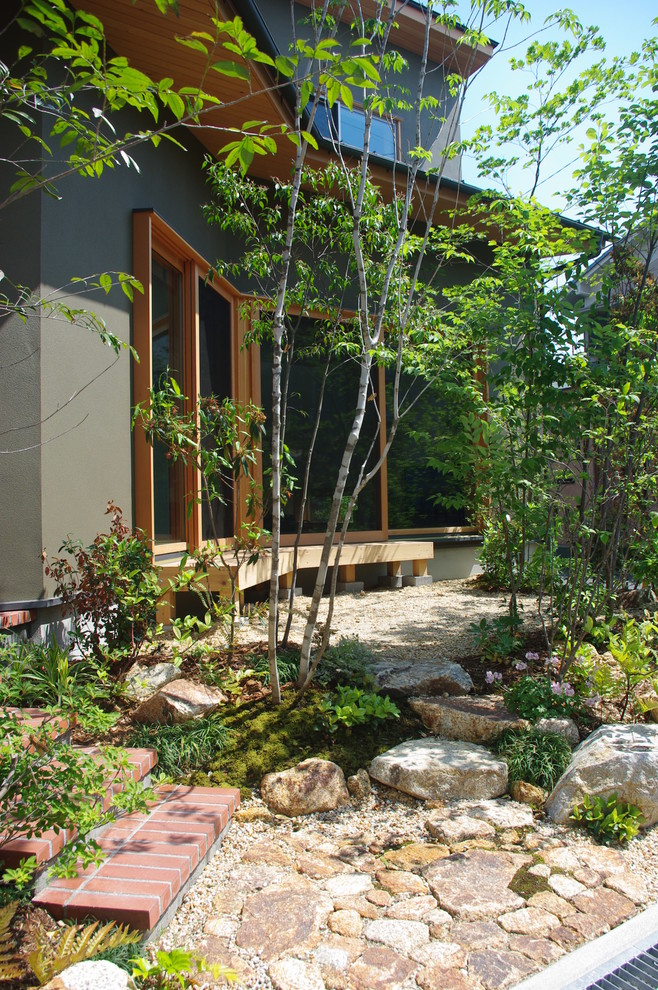 Foto di un giardino esposto in pieno sole davanti casa con pavimentazioni in pietra naturale