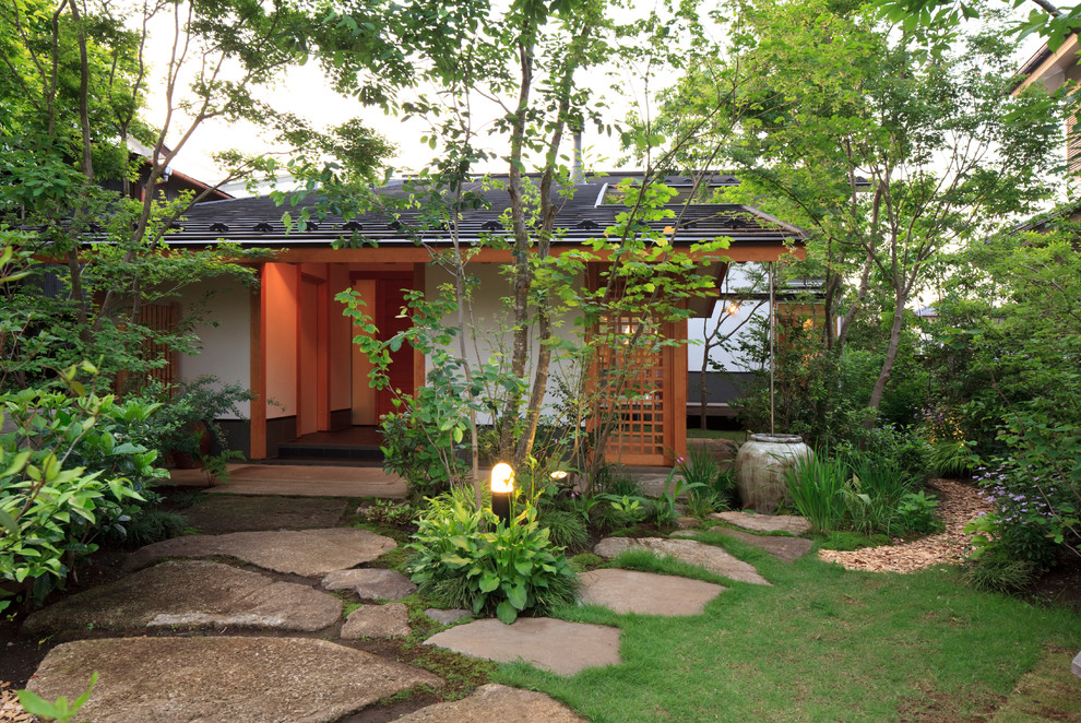 Imagen de acceso privado asiático en patio delantero con adoquines de piedra natural