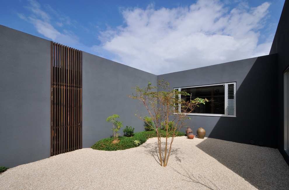 This is an example of a small asian courtyard gravel landscaping in Other.