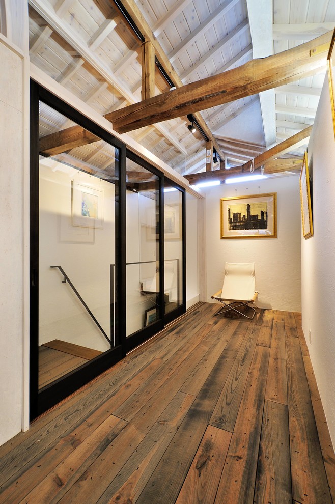 Hallway - farmhouse dark wood floor and brown floor hallway idea in Other with brown walls