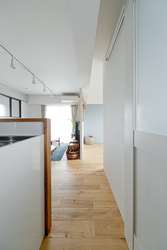 Imagen de recibidores y pasillos escandinavos con paredes blancas, suelo de madera en tonos medios y suelo beige