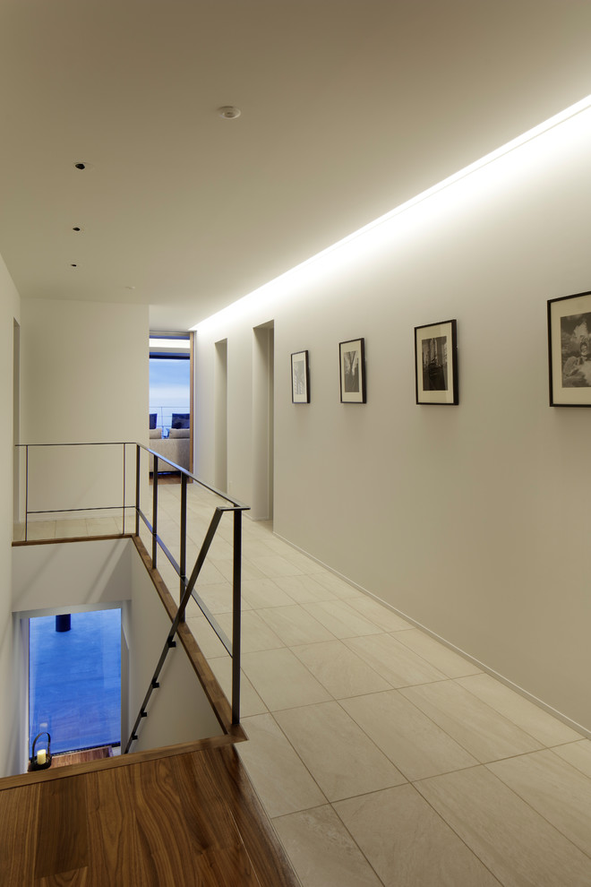 Идея дизайна: коридор среднего размера в стиле модернизм с белыми стенами и бежевым полом