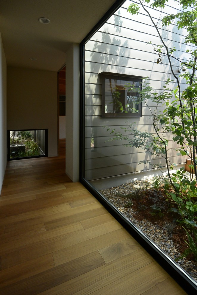 Réalisation d'un couloir minimaliste avec un sol en bois brun.