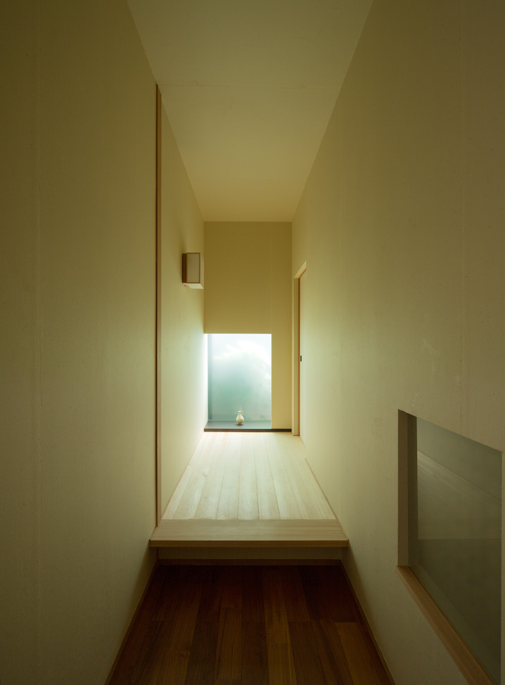 Ejemplo de recibidores y pasillos asiáticos con paredes beige y suelo de madera clara