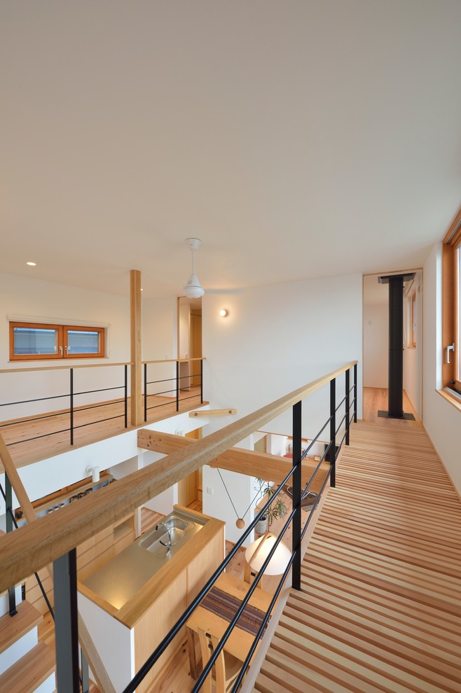 Diseño de recibidores y pasillos asiáticos con paredes blancas, suelo de madera en tonos medios y suelo marrón
