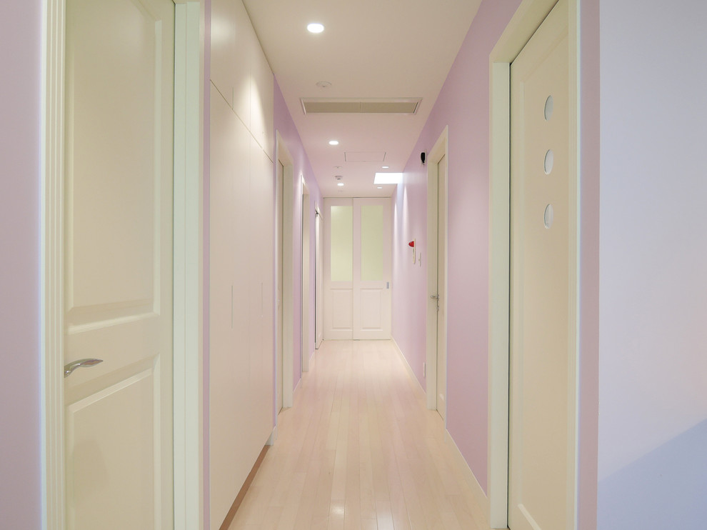 他の地域にあるトランジショナルスタイルのおしゃれな廊下 (紫の壁、塗装フローリング、ベージュの床) の写真
