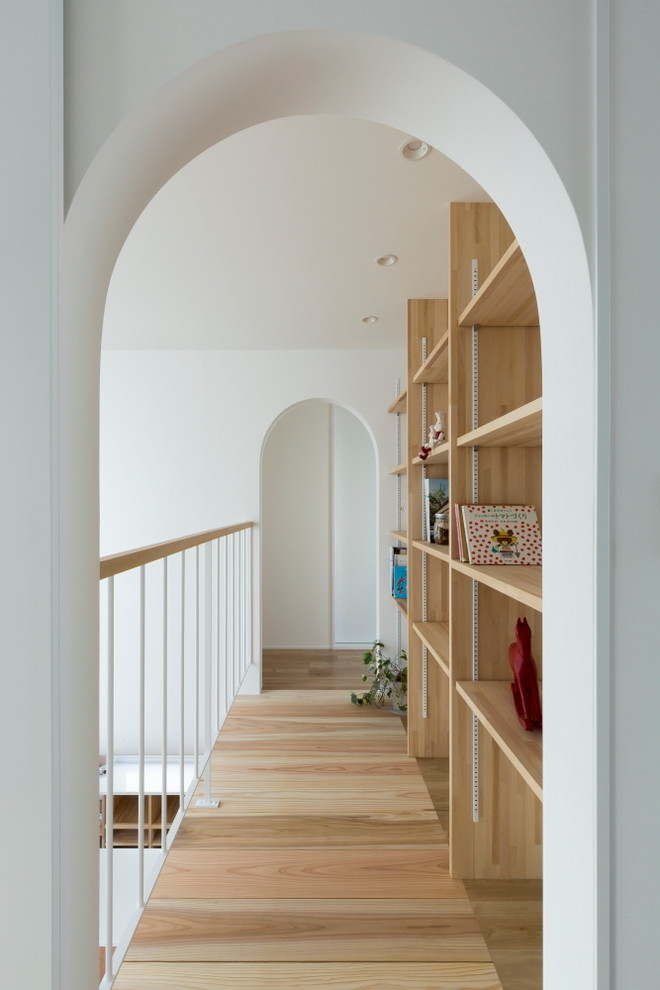Imagen de recibidores y pasillos de estilo zen de tamaño medio con paredes blancas, suelo de madera clara y suelo beige