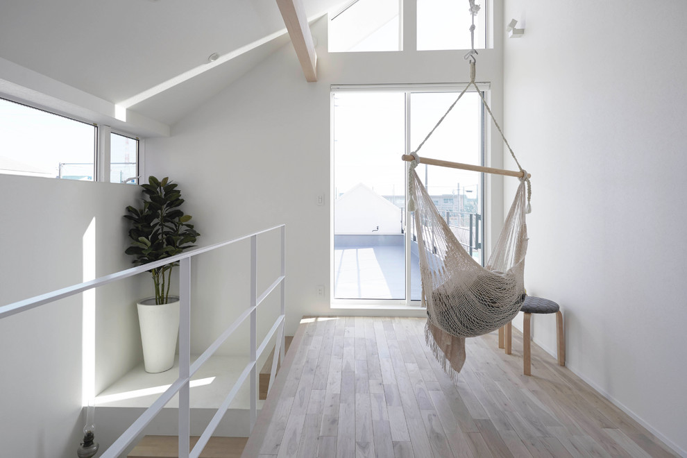Imagen de recibidores y pasillos nórdicos con paredes blancas, suelo de madera clara y suelo beige