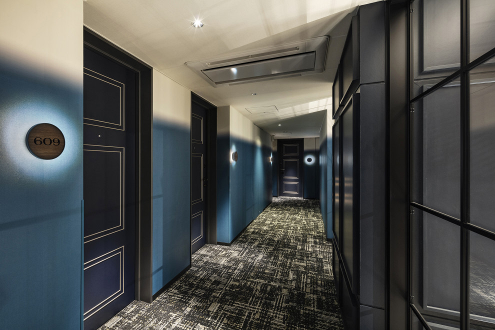 Ispirazione per un ampio ingresso o corridoio design con pareti blu, moquette, pavimento verde, soffitto in carta da parati e carta da parati