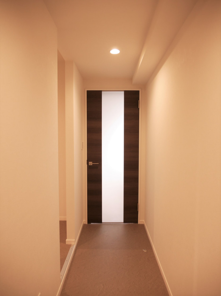 Bild på en liten hall, med vita väggar, vinylgolv och grått golv