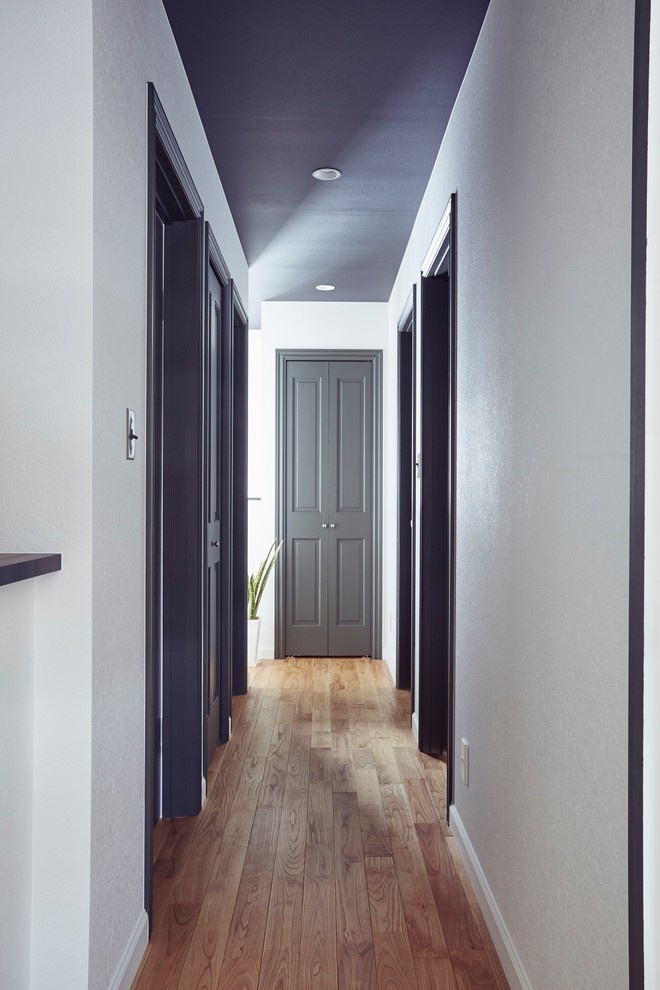 Idee per un ingresso o corridoio chic con pareti bianche, pavimento in legno massello medio e pavimento marrone