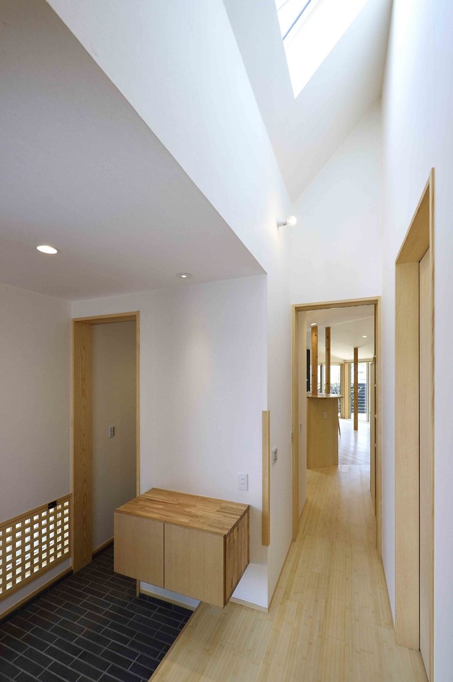 Diseño de recibidores y pasillos rústicos de tamaño medio con paredes blancas, suelo de bambú y suelo beige