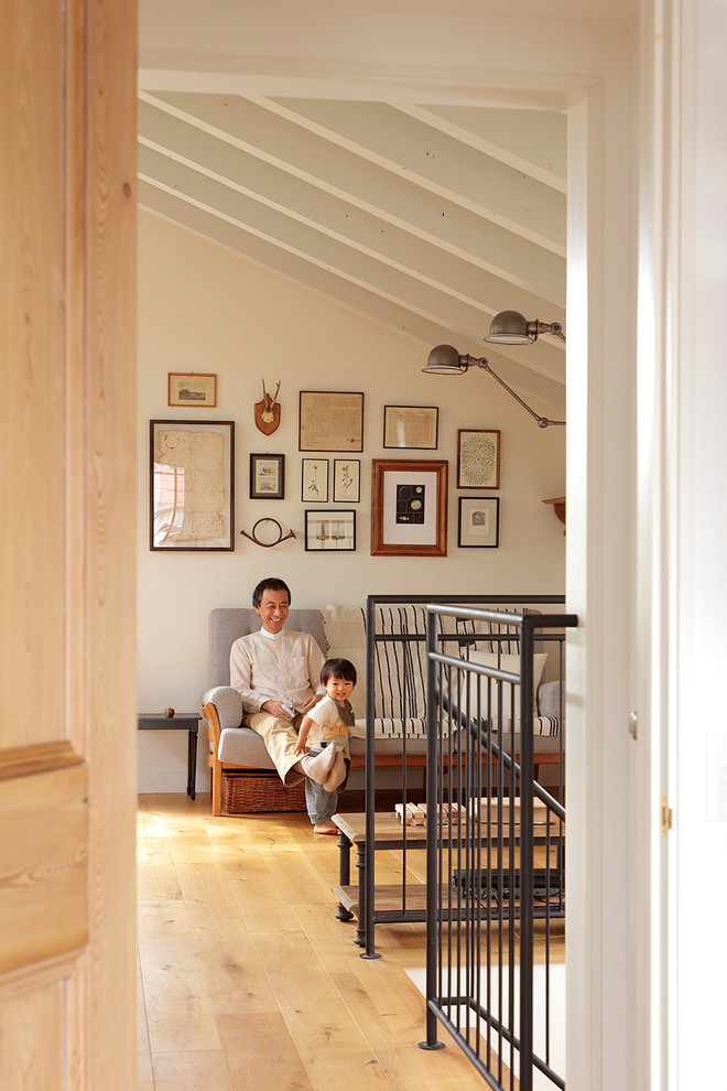 Idée de décoration pour un couloir nordique avec un mur blanc, parquet clair et un sol beige.