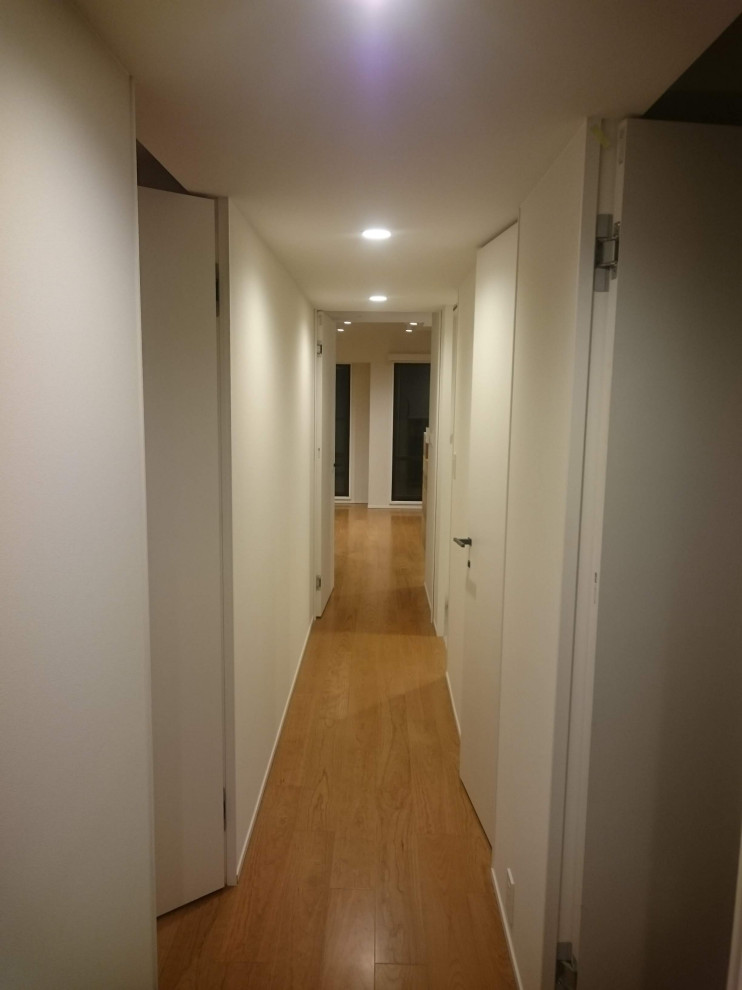 Foto di un ingresso o corridoio minimalista di medie dimensioni con pavimento in legno massello medio, pavimento beige, soffitto in carta da parati e carta da parati