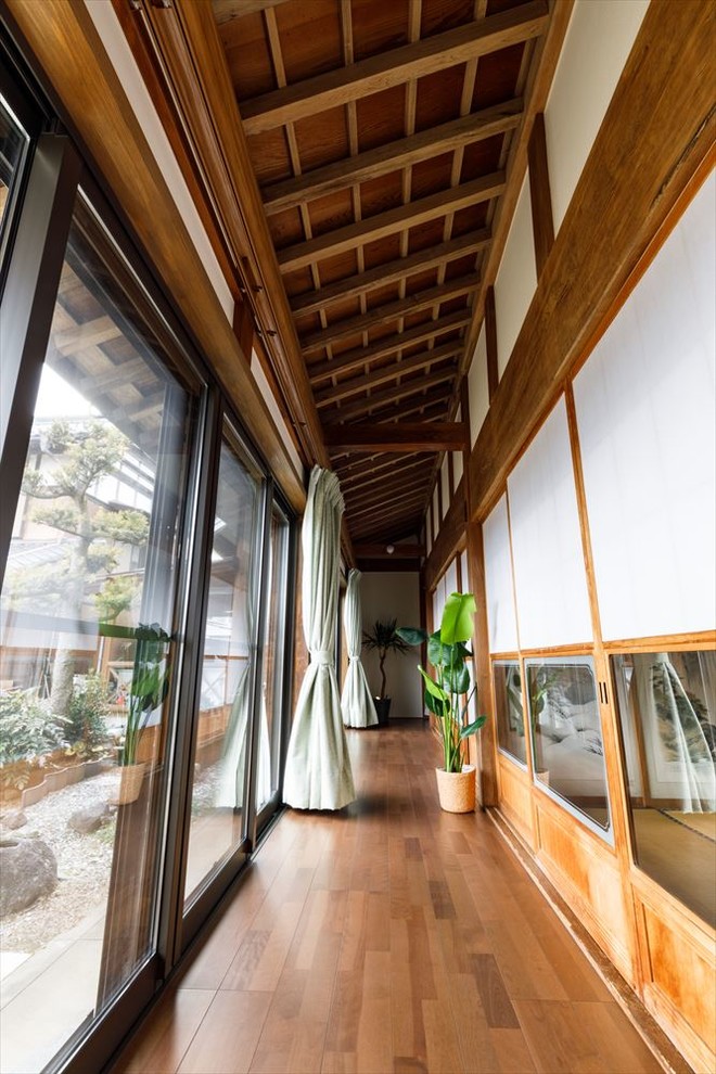 Imagen de recibidores y pasillos de estilo zen con suelo de madera en tonos medios y suelo marrón