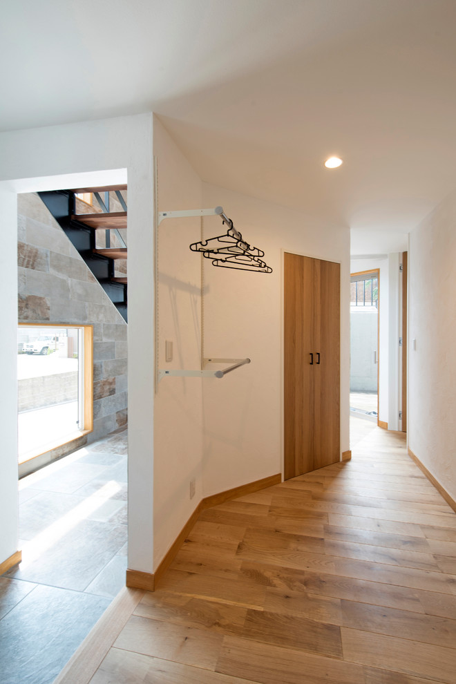 Идея дизайна: коридор в современном стиле с белыми стенами, паркетным полом среднего тона и коричневым полом