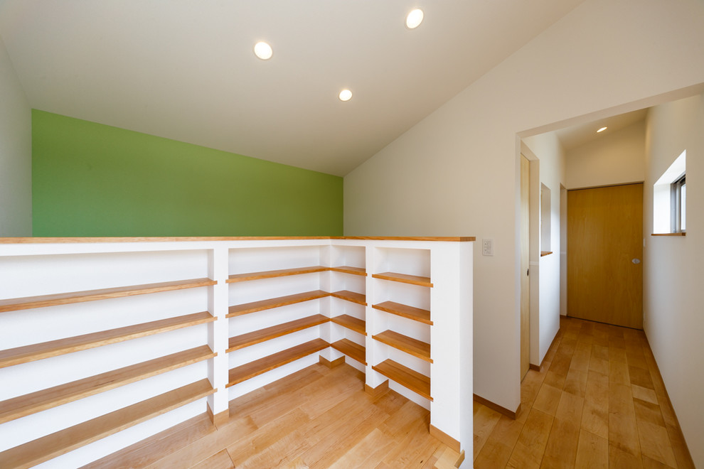 Ejemplo de recibidores y pasillos modernos con paredes blancas, suelo de madera en tonos medios y suelo beige