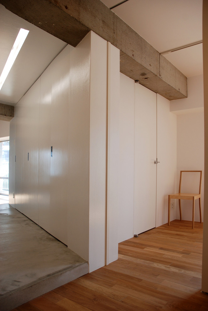 Idee per un ingresso o corridoio minimal con pareti bianche, pavimento in cemento e pavimento beige