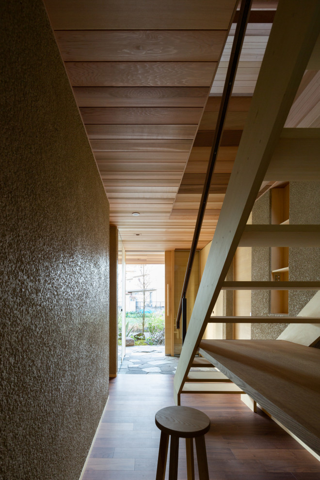 Idee per un piccolo ingresso o corridoio nordico con pareti beige, parquet scuro, pavimento marrone e soffitto in legno