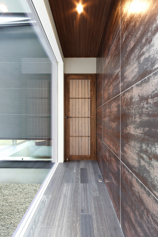 Пример оригинального дизайна: коридор с коричневыми стенами, паркетным полом среднего тона и серым полом