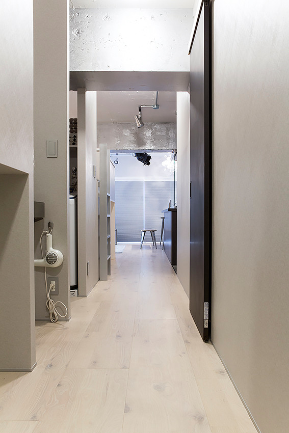 Idées déco pour un petit couloir contemporain avec un mur gris, un sol en contreplaqué et un sol beige.