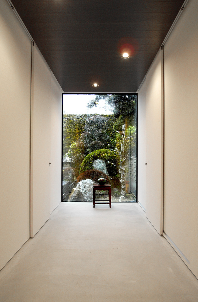 Идея дизайна: коридор среднего размера в восточном стиле с белыми стенами, бетонным полом и белым полом