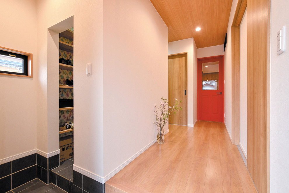 Idee per un ingresso o corridoio nordico con pareti bianche, pavimento in legno massello medio e pavimento marrone